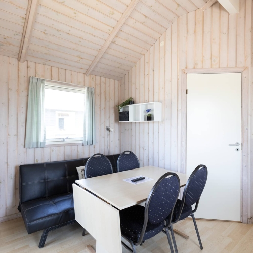 Sofa og spisebord i hytte på 25m2 på Storebælt Camping